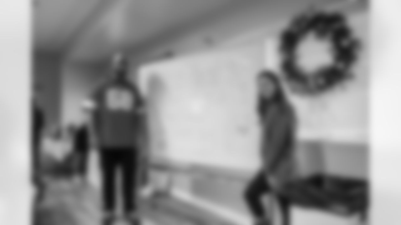 Detroit Lions tackle Taylor Decker (68) and Kyndra Decker pose for a photo with a decorated whiteboard during a Thanksgiving lunch event at Alternatives For Girls on Nov. 28, 2025 in Detroit. (Izzy Rincon/Detroit Lions)