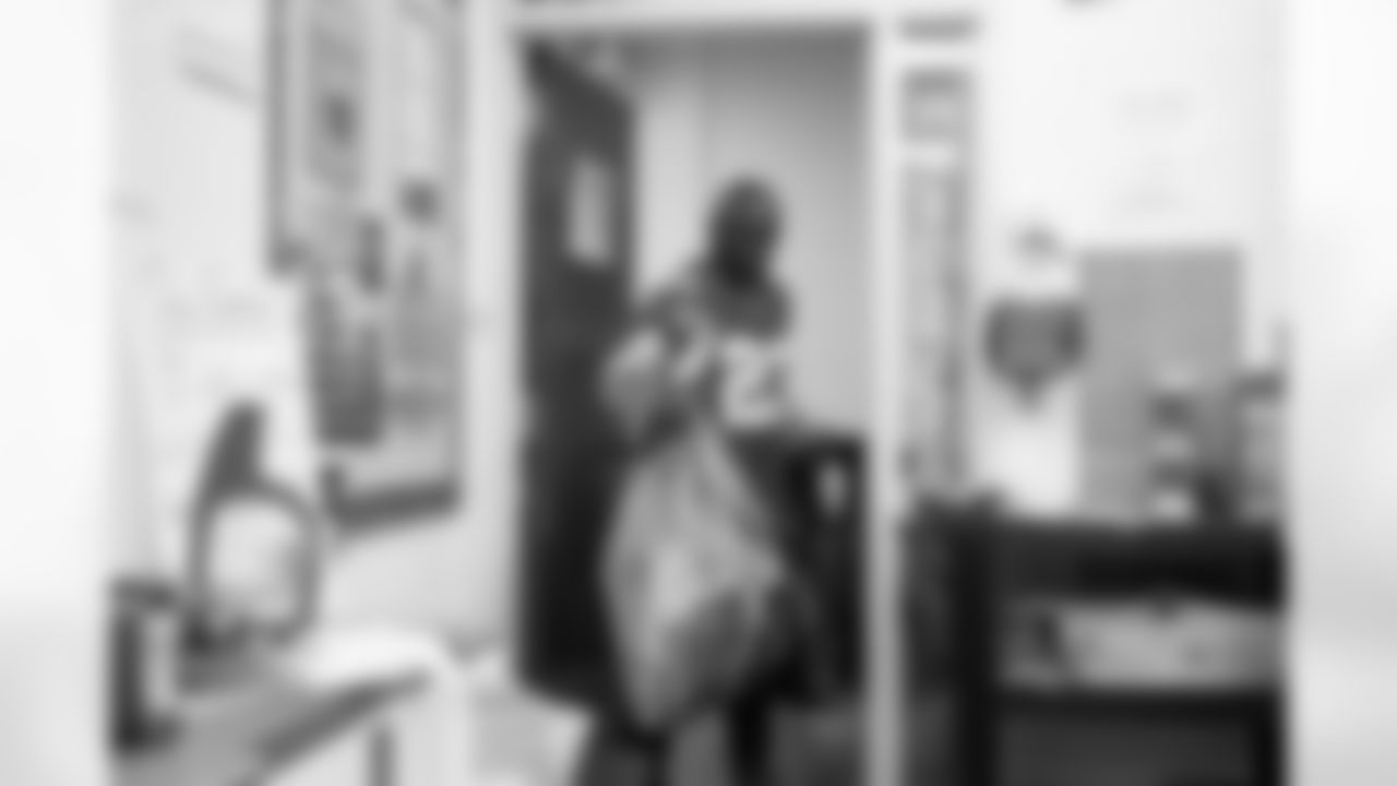 Lions Legend Maurice Harvey (23) carrying in presents during the Presents from the Pride event at Detroit Lions Academy on Dec. 16, 2025 in Detroit. (Izzy Rincon/Detroit Lions)