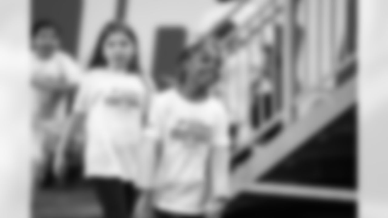 A participant smiling while taking the field during the Inspire Change Football Clinic at Ford Field on Dec. 9, 2025 in Detroit. (Izzy Rincon/Detroit Lions)
