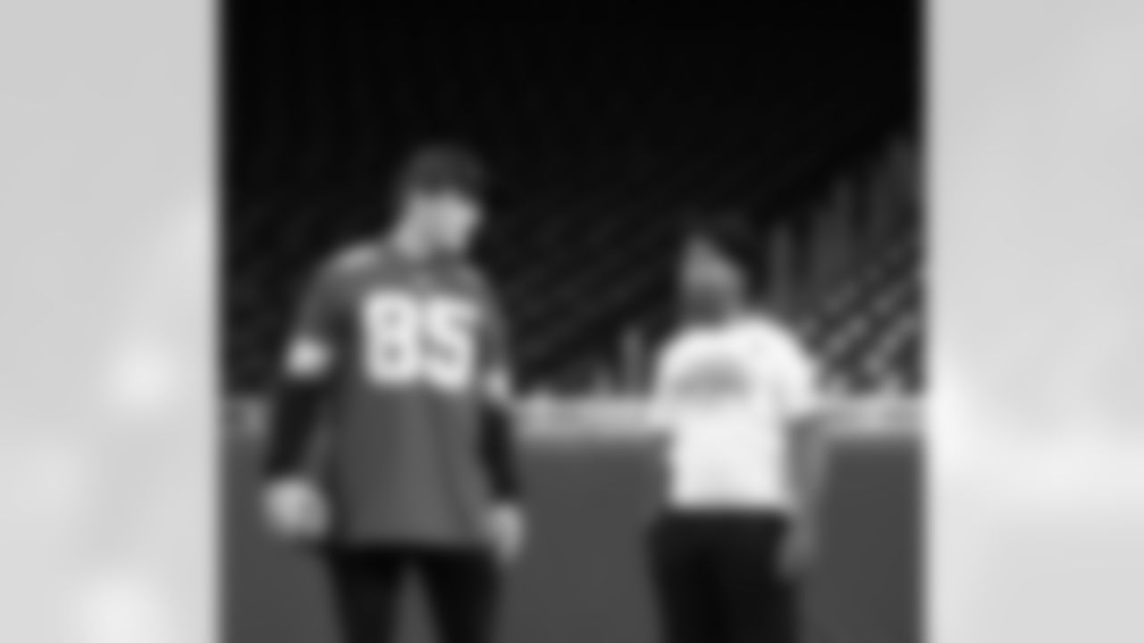 Detroit Lions wide receiver Tom Kennedy (85) talking with a participant during the Inspire Change Football Clinic at Ford Field on Dec. 9, 2025 in Detroit. (Izzy Rincon/Detroit Lions)