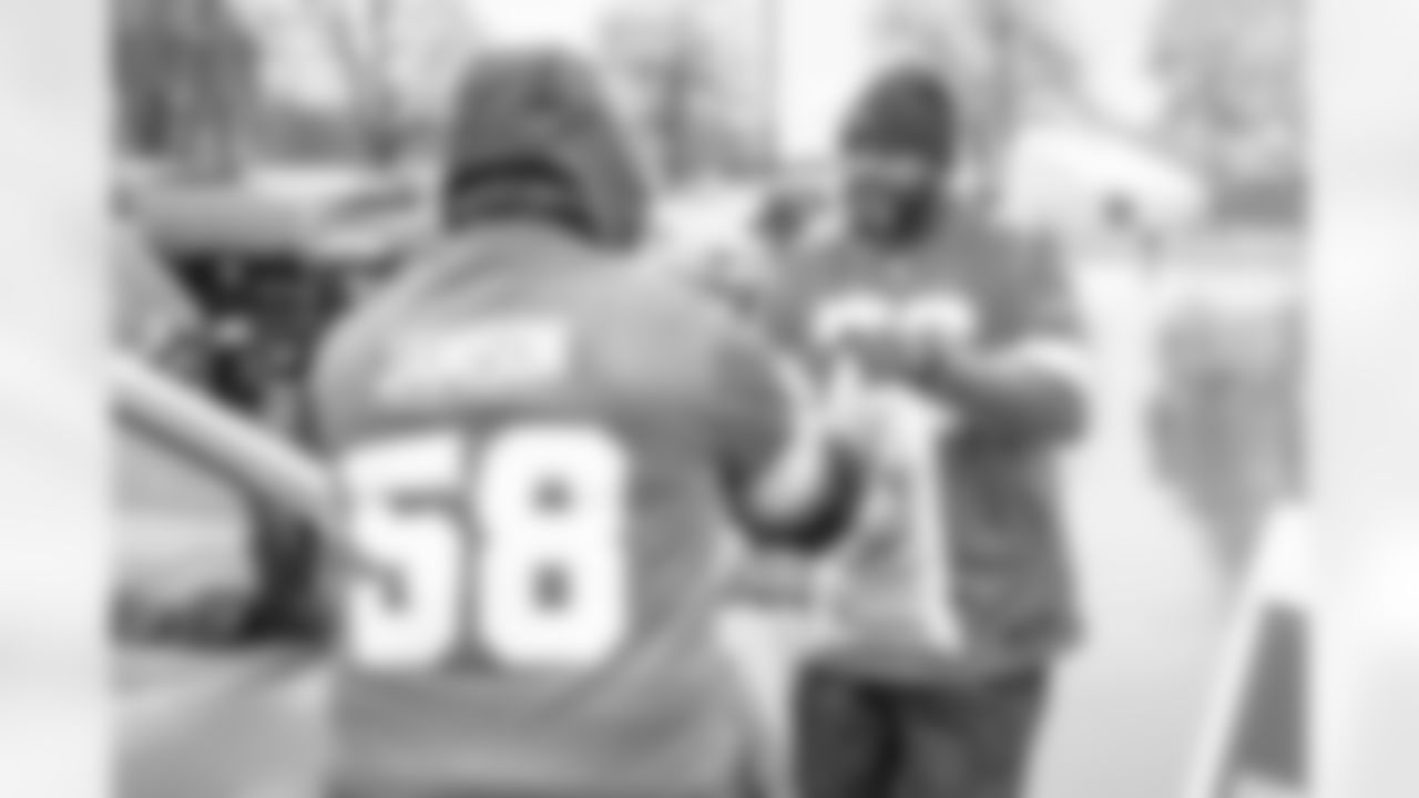 Lions Legend George Jamison (58) and Lions Legend Scott Conover (76) help load cars during a Thanksgiving meal kit distribution event at the Detroit Lions Academy in Detroit, MI on November 20, 2024. (Mike Ferdinande/Detroit Lions)