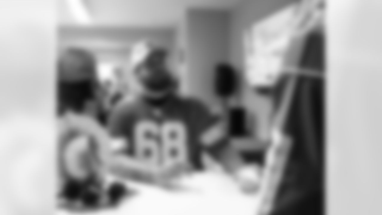 Detroit Lions tackle Taylor Decker (68) signing autographs during a Thanksgiving lunch event at Alternatives For Girls on Nov. 28, 2025 in Detroit. (Izzy Rincon/Detroit Lions)