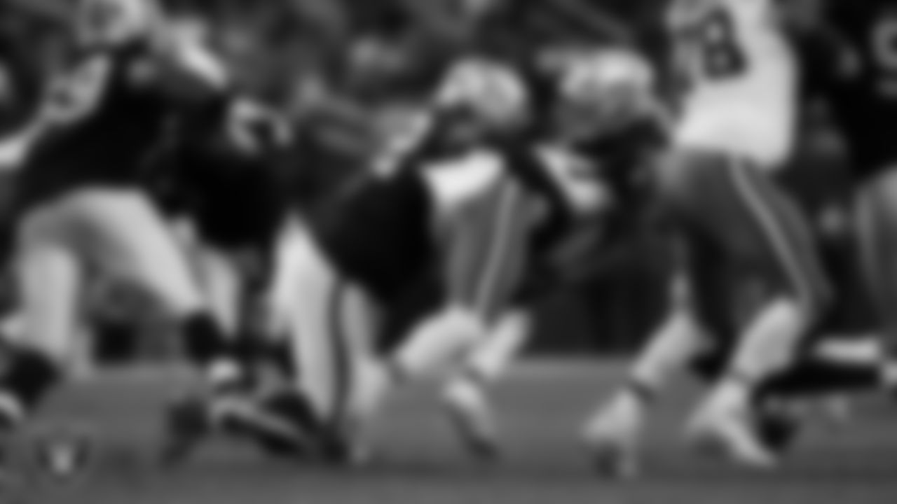 Las Vegas Raiders defensive tackle JJ Pegues (92) and defensive end Charles Snowden (49) make a tackle during the regular season home game against the Cleveland Browns at Allegiant Stadium.