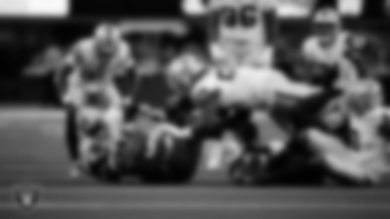 Las Vegas Raiders linebacker Jamal Adams (33) and defensive tackle Adam Butler (69) make a tackle during the regular season away game against the Los Angeles Chargers at SoFi Stadium.