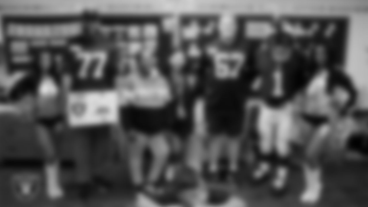 Raiderettes Kylee and Cierra, Raider Rusher and Las Vegas Raiders tackle Thayer Munford Jr. (77) and center Will Putnam (67) pose for a photo with a teacher while celebrating Teacher Appreciation Week at Matt Kelly Elementary School.