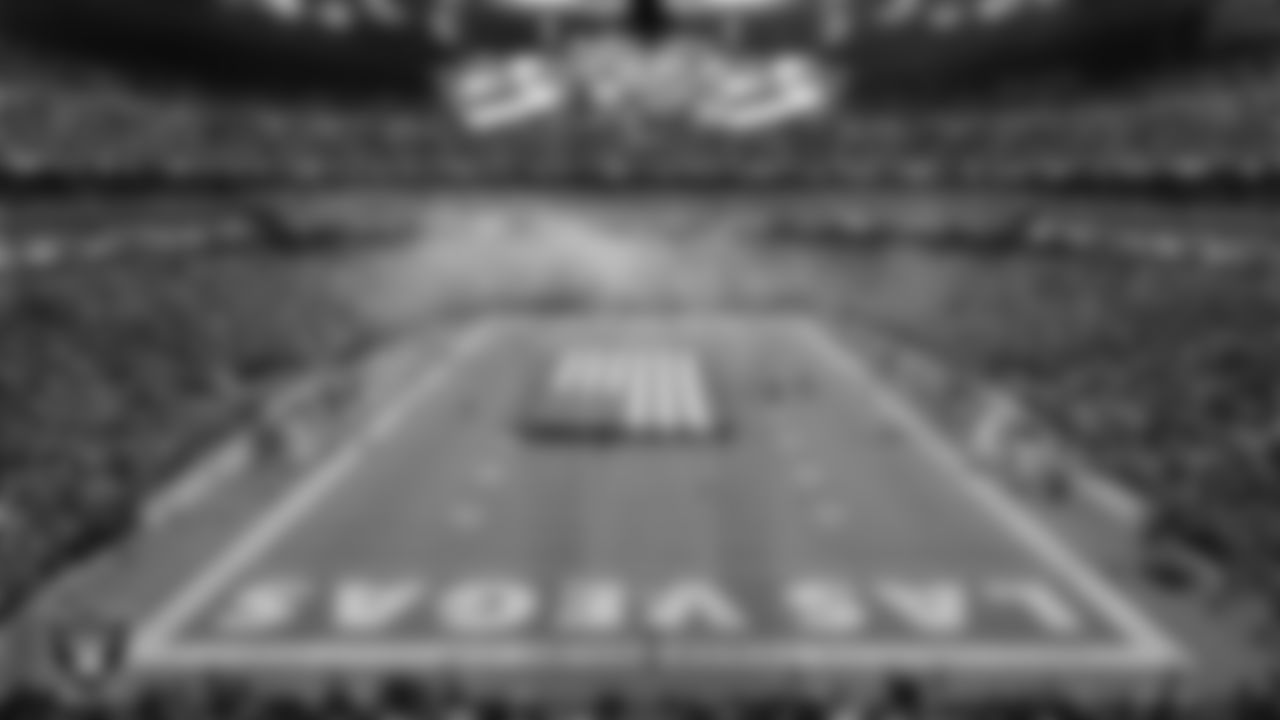 The American flag is displayed by Personal Seat License (PSL) holders on the field during the national anthem before the Las Vegas Raiders' preseason home game against the San Francisco 49ers at Allegiant Stadium.