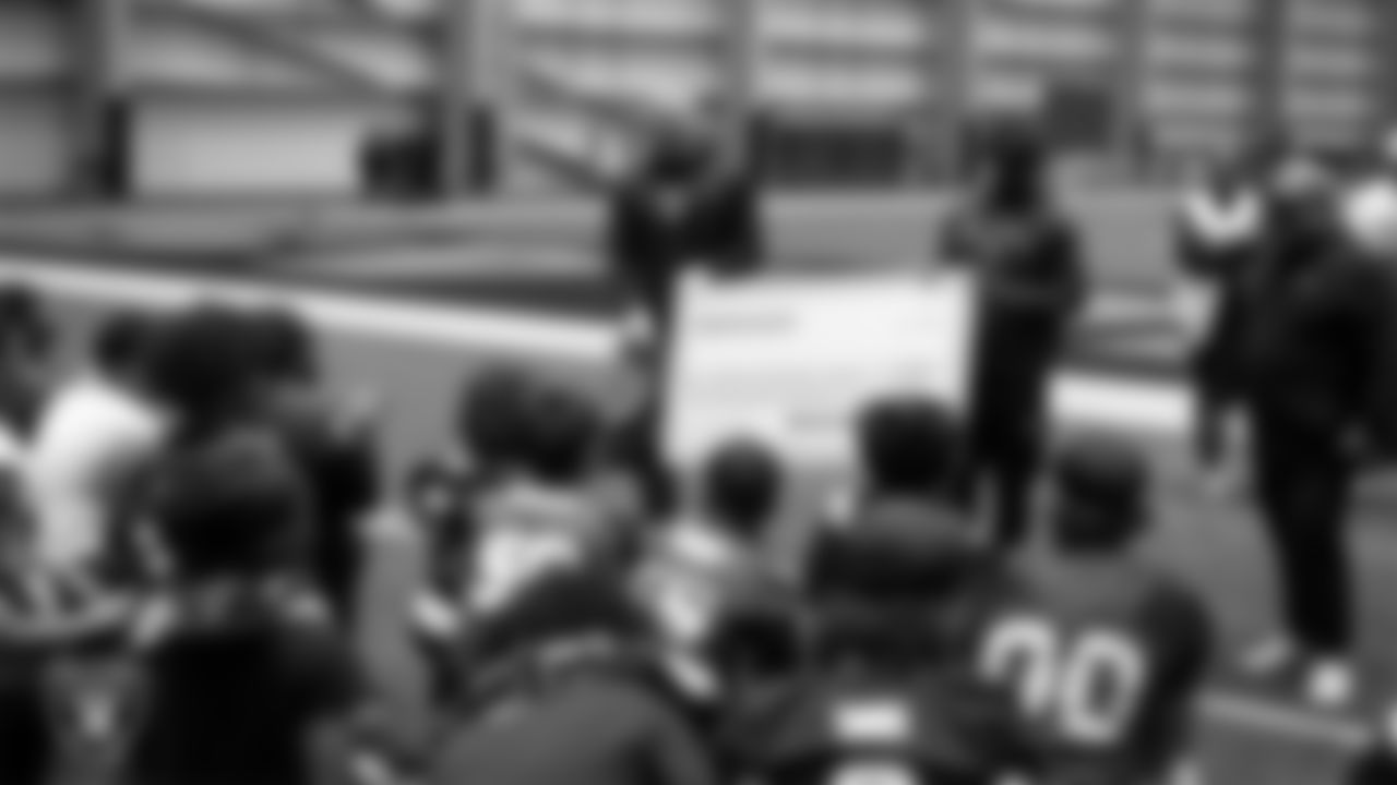 Las Vegas Raiders linebacker Tommy Eichenberg (44) and wide receiver Phillip Dorsett II (13) present athletes with a check to go towards their travels for nationals during an open practice at Intermountain Health Performance Center.