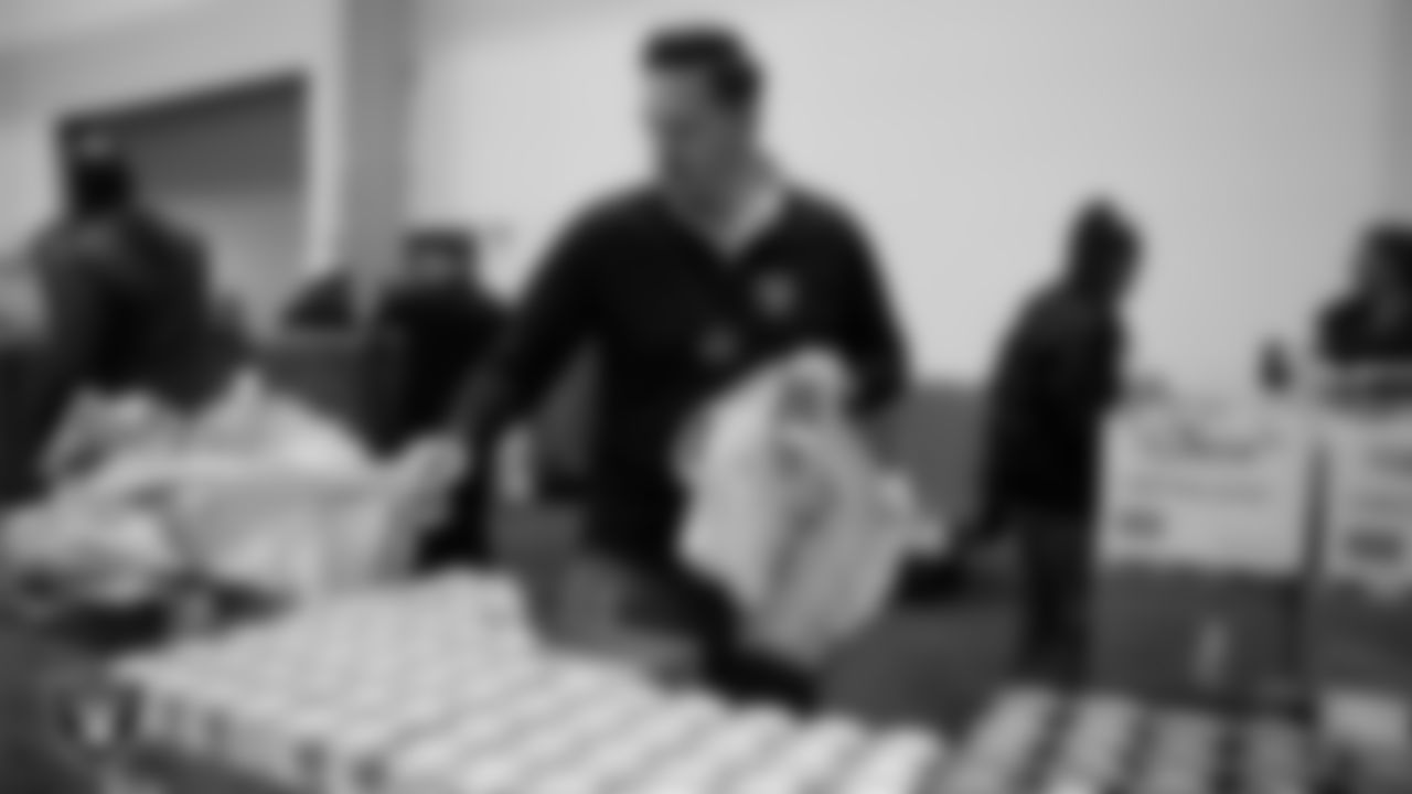 Las Vegas Raiders staff members help pack meals during the Raiders Holiday Meal Packing Party at Intermountain Health Performance Center.