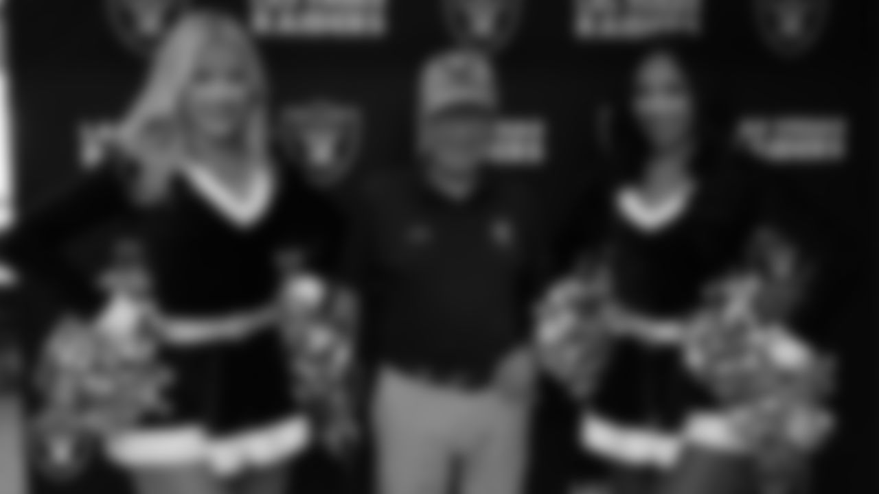 Raiderettes Kennedy and Cierra pose for a photo with a veteran during the annual Cox Salute to Service Tailgate at Southern Nevada State Veterans Home.