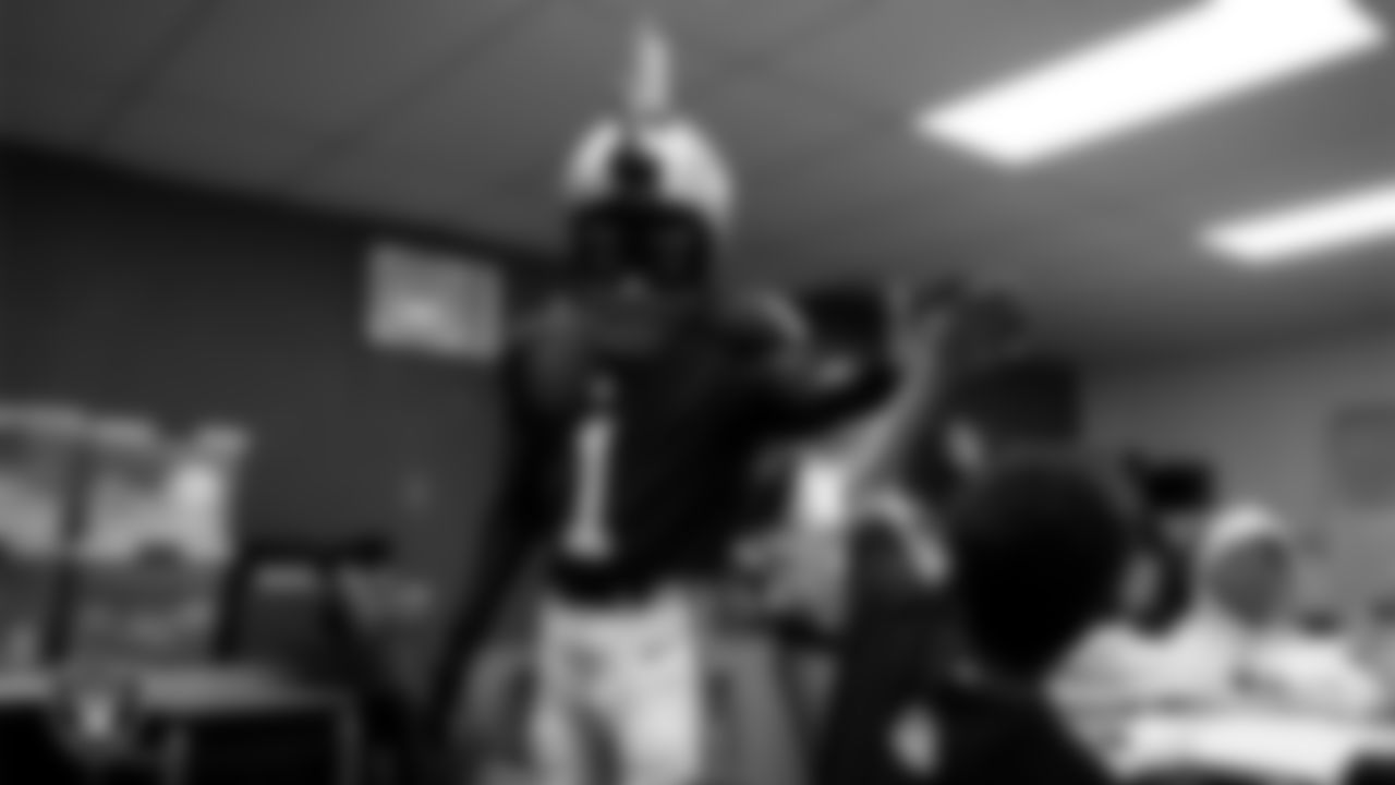 Raider Rusher gives a high-five to a student during a 'Lil Raiders Pop-Up at Matt Kelly Elementary School.