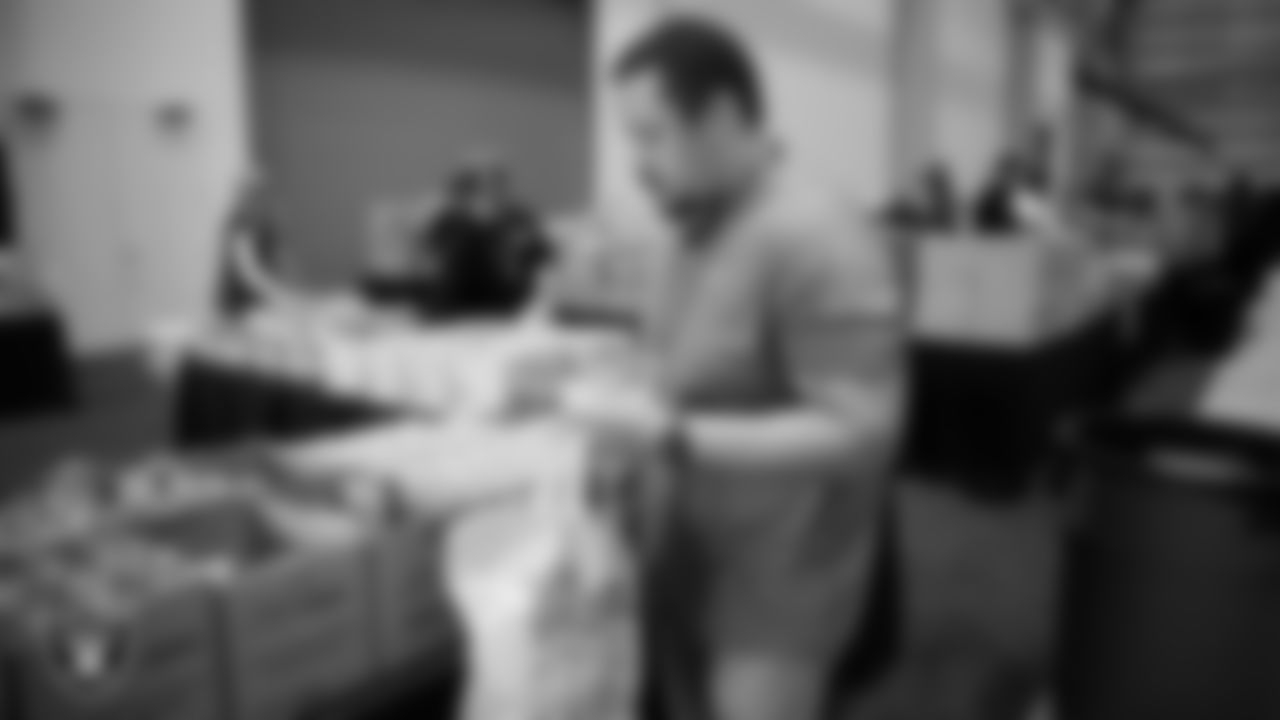 Las Vegas Raiders staff members help pack meals during the Raiders Holiday Meal Packing Party at Intermountain Health Performance Center.