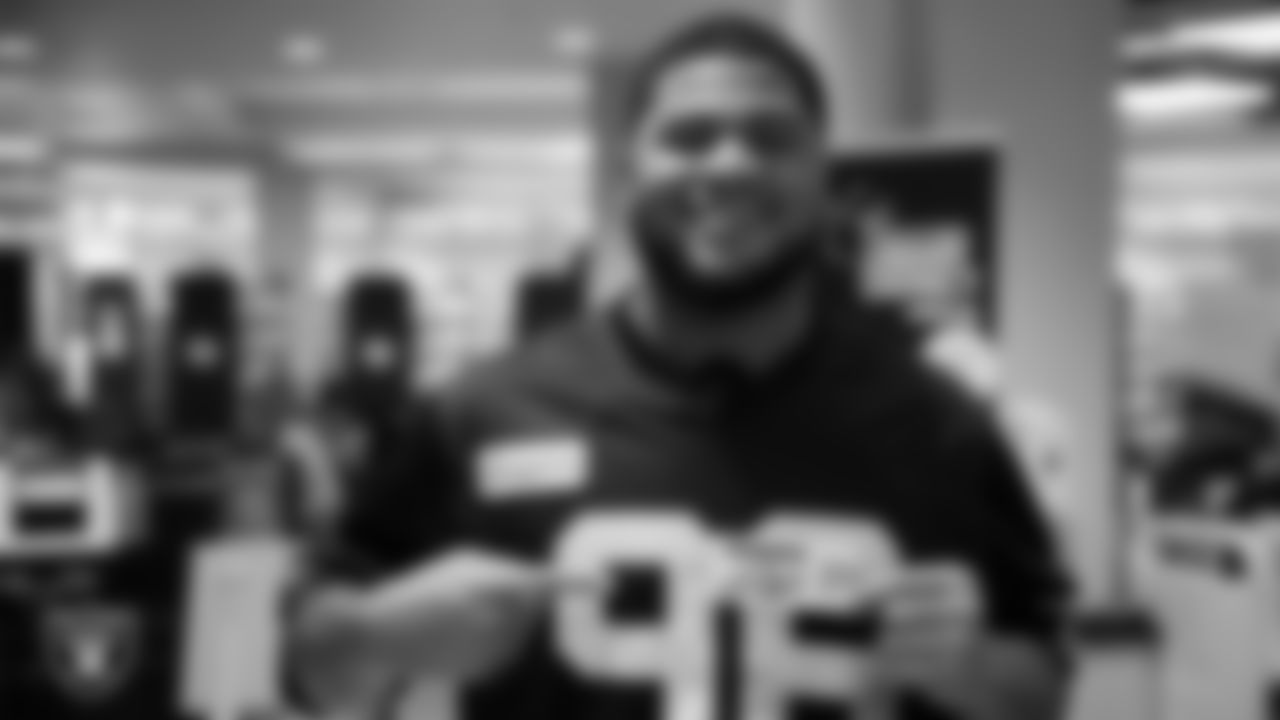 Las Vegas Raiders defensive tackle Jonah Laulu (96) poses for photo with his Raiders edition library card during a launch event at Aliante Library.