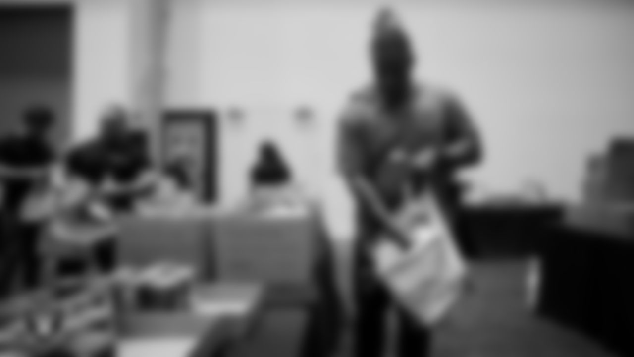 Las Vegas Raiders staff members help pack meals during the Raiders Holiday Meal Packing Party at Intermountain Health Performance Center.