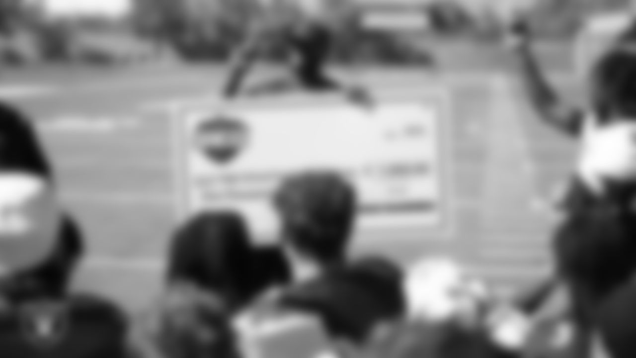 Arbor View High School football coach Marlon Barnett shows off a donation check during practice at Arbor View High School.