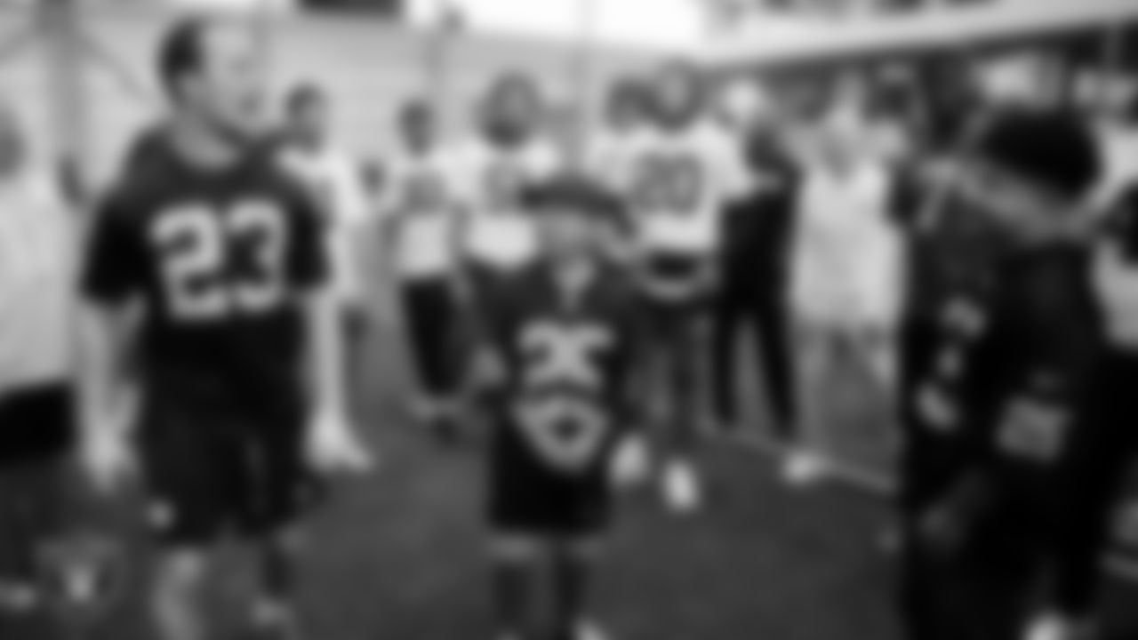 Las Vegas Raiders running back Dylan Laube (23) fires up the team with Christopher Arias and Marcos Carrillo from Make-A-Wish after practice during a visit to Intermountain Health Performance Center.