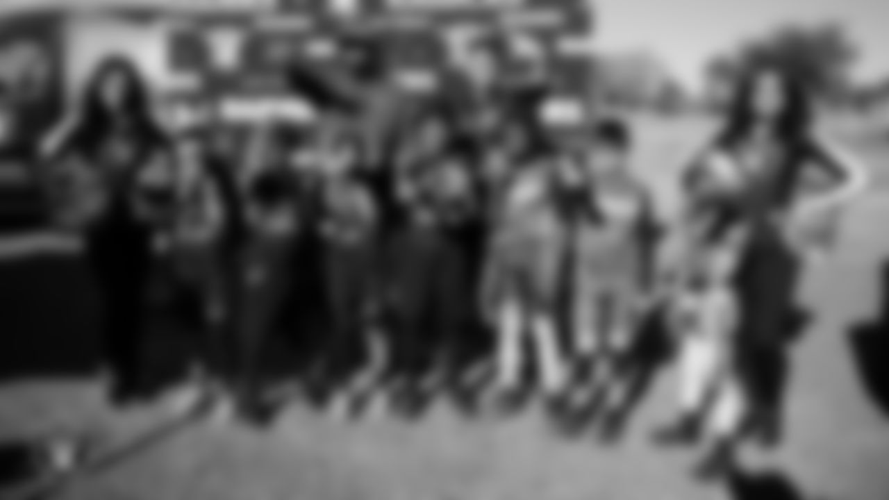 Raiderettes Kylee and Sloane pose for a photo with athletes during the LEEAP Flag Football Tournament at Desert Breeze Park.
