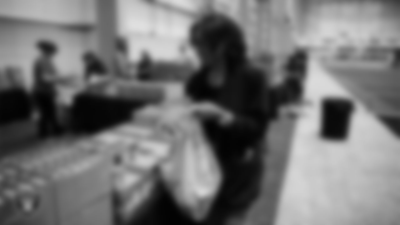 Las Vegas Raiders staff members help pack meals during the Raiders Holiday Meal Packing Party at Intermountain Health Performance Center.