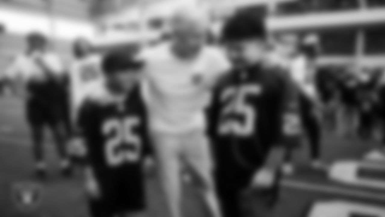 Christopher Arias and Marcos Carrillo from Make-A-Wish with Las Vegas Raiders Head Coach Pete Carroll after practice during a visit to Intermountain Health Performance Center.