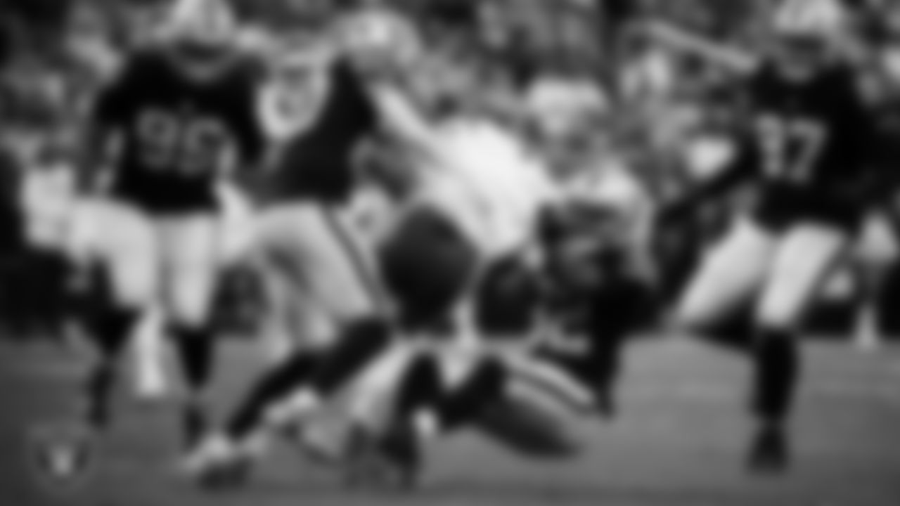 Las Vegas Raiders safety Isaiah Pola-Mao (20) and safety Lonnie Johnson Jr. (32) make a tackle during the regular season home game against the Kansas City Chiefs at Allegiant Stadium.