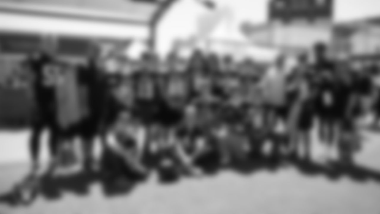 Las Vegas Raiders linebacker Cody Lindenberg (55), linebacker Matt Jones (42), linebacker Tommy Eichenberg (44) and linebacker Amari Gainer (53) pose for a photo with the Round Mountain High School football team during a 2025 Training Camp practice at Intermountain Health Performance Center.