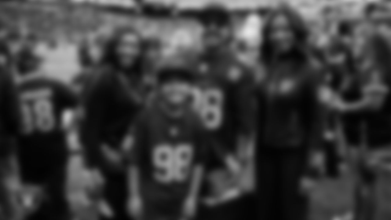 Las Vegas Raiders senior director of community relations Ebere Arum and President Sandra Douglass Morgan pose for a photo with Christopher Arias and his dad from Make-A-Wish on the sidelines before the Raiders' regular season home game against the Jacksonville Jaguars at Allegiant Stadium.