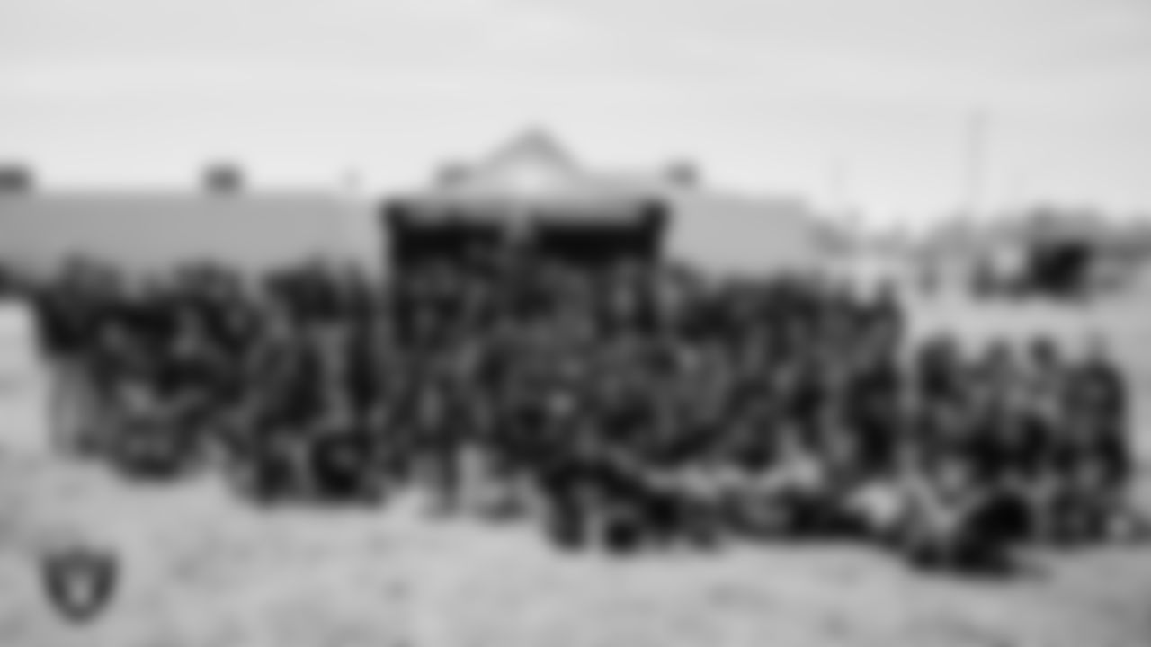 Raider Rusher poses for a photo with students after a Raiders Junior Training Camp at Berkeley Bunker Elementary School.