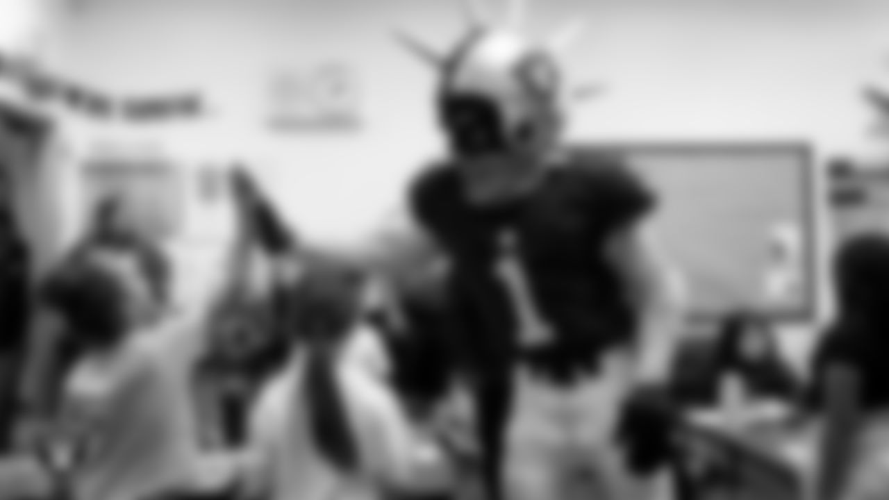 Raider Rusher gives a high-five to a student during a 'Lil Raiders Pop-Up at Richard H. Bryan Elementary School.