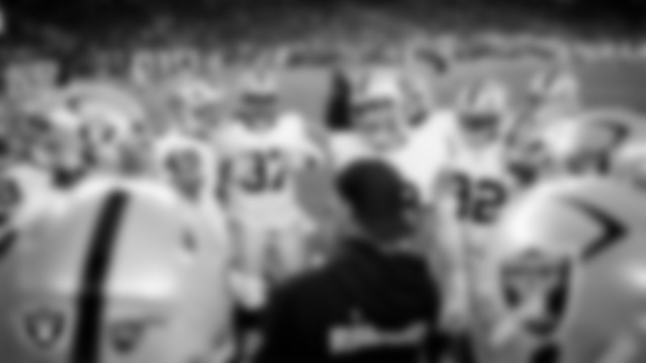 The Las Vegas Raiders defensive linemen and run game coordinator/defensive line coach Rob Leonard huddle before the preseason away game against the Arizona Cardinals at State Farm Stadium.