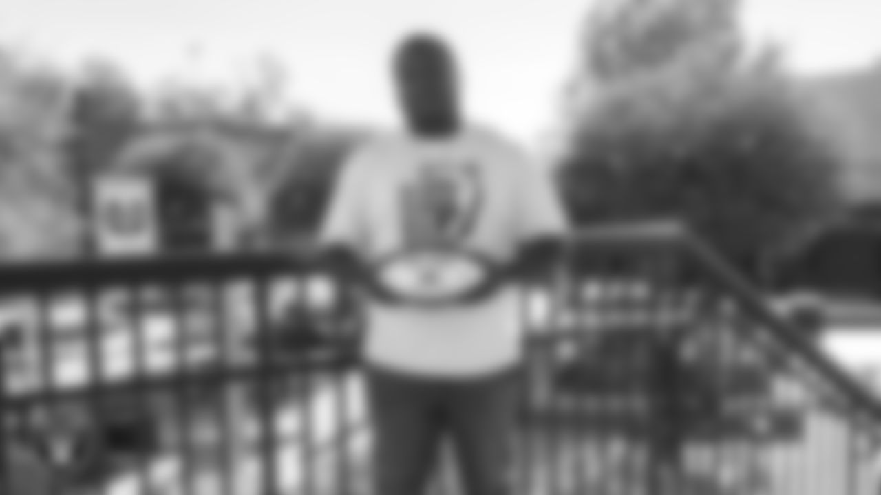 Spring Valley High School football coach Eric Dyer poses for a photo with the Tom Flores Coach of the Week custom football after practice at Spring Valley High School.