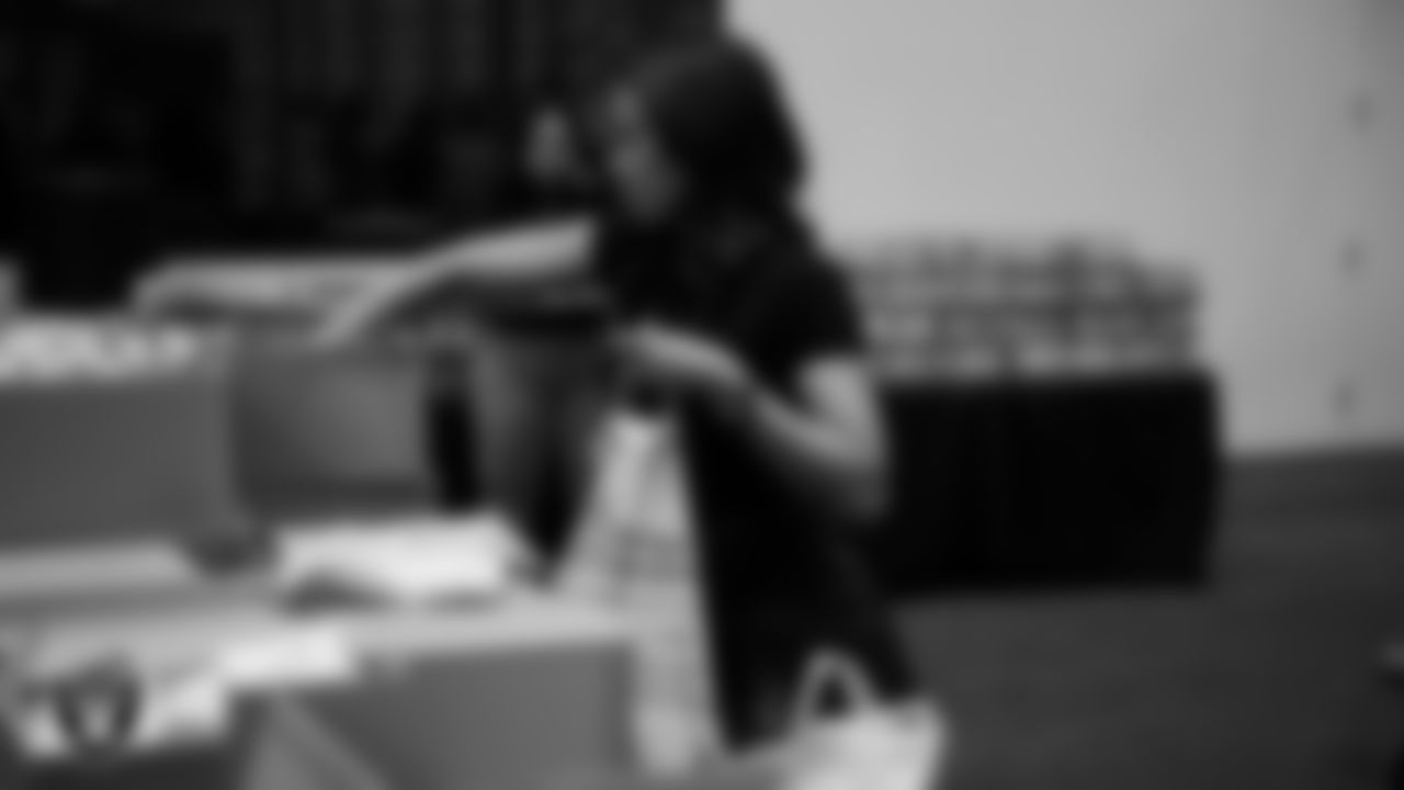 Las Vegas Raiders staff members help pack meals during the Raiders Holiday Meal Packing Party at Intermountain Health Performance Center.