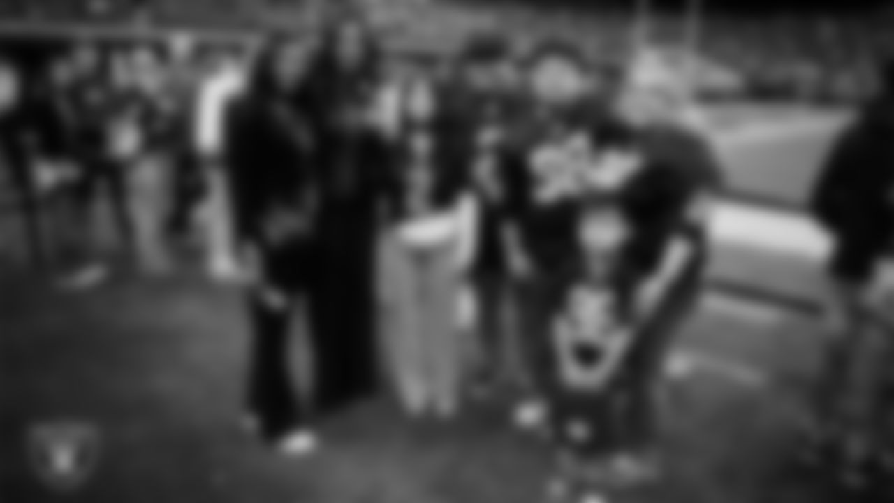 Las Vegas Raiders senior director of community relations Ebere Arum and President Sandra Douglass Morgan pose for a photo with Marcos Carrillo and his family from Make-A-Wish on the sidelines before the Raiders' regular season home game against the Jacksonville Jaguars at Allegiant Stadium.