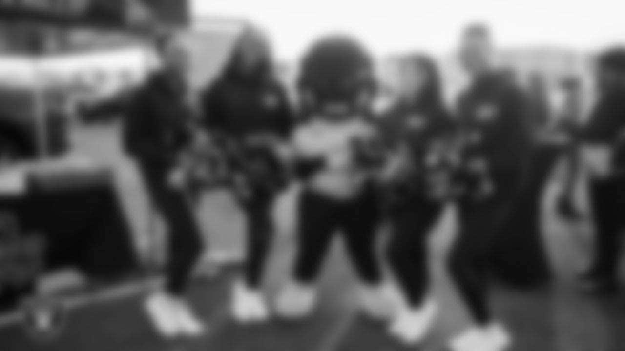 The Nevada State University dance team and mascot pose for a photo at a tailgate during the inaugural women's flag football game at Intermountain Health Performance Center.