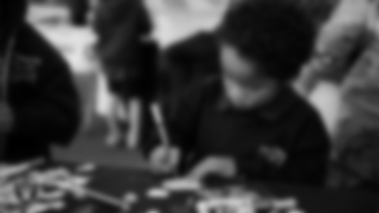 A child decorates ornaments during the Raiders Holiday Salute at Nellis Air Force Base - Coral Academy.