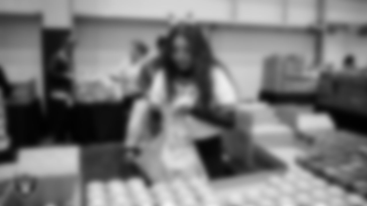 Las Vegas Raiders staff members help pack meals during the Raiders Holiday Meal Packing Party at Intermountain Health Performance Center.