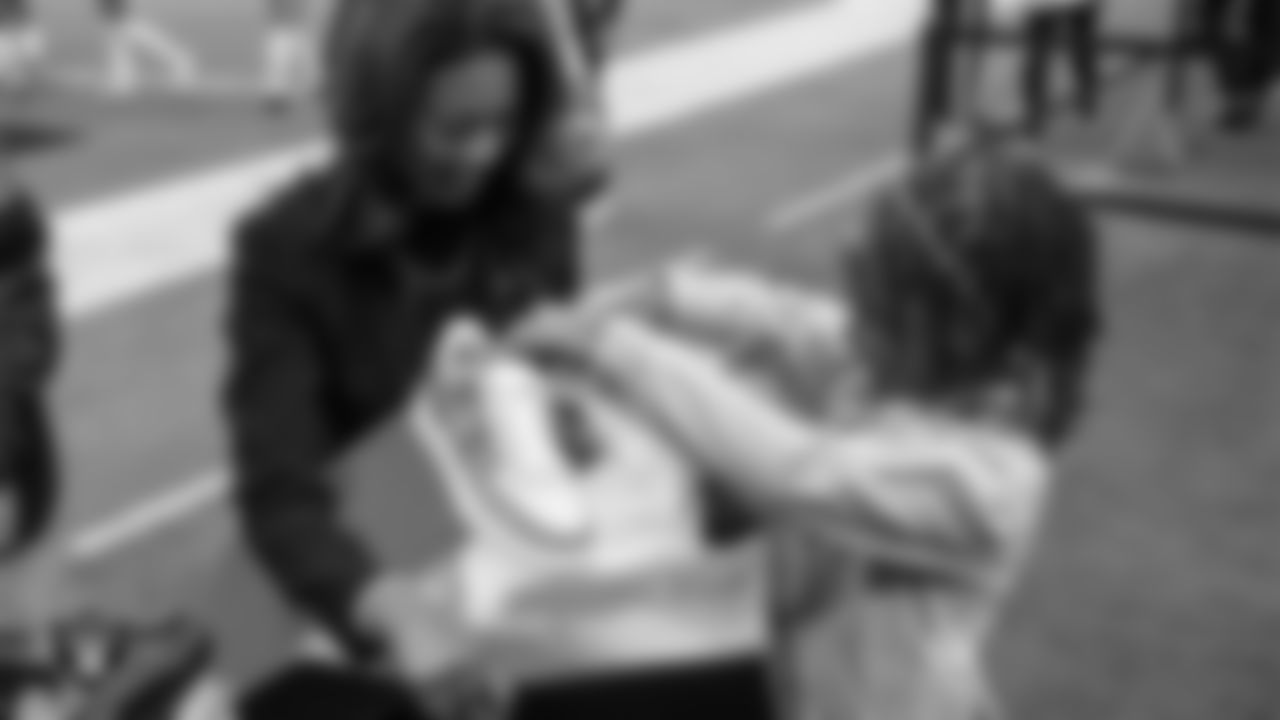 Las Vegas Raiders President Sandra Douglass Morgan helps Intermountain Children's Health patient Evelyn unbox her custom shoes for the NFL's My Cause My Cleats initiative before the Raiders' regular season home game against the Cleveland Browns at Allegiant Stadium.