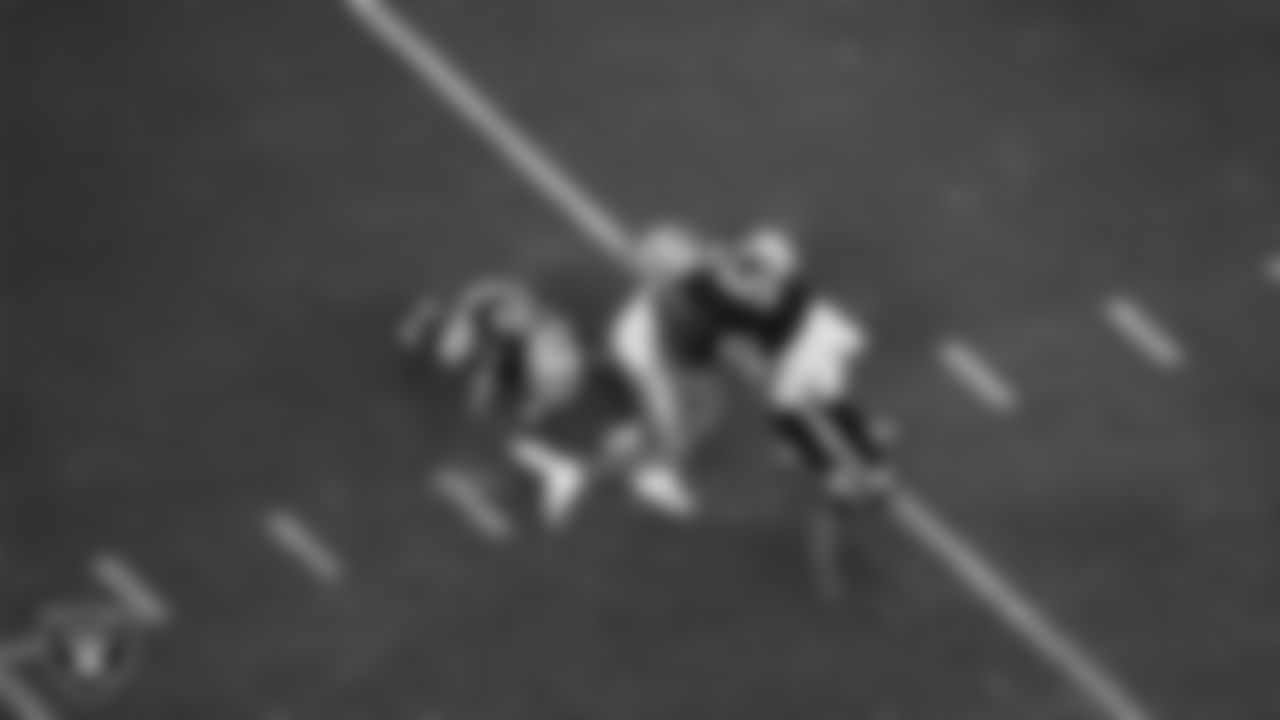Las Vegas Raiders defensive end Malcolm Koonce (51) and safety Isaiah Pola-Mao (20) make a tackle during the regular season home game against the Los Angeles Chargers at Allegiant Stadium.