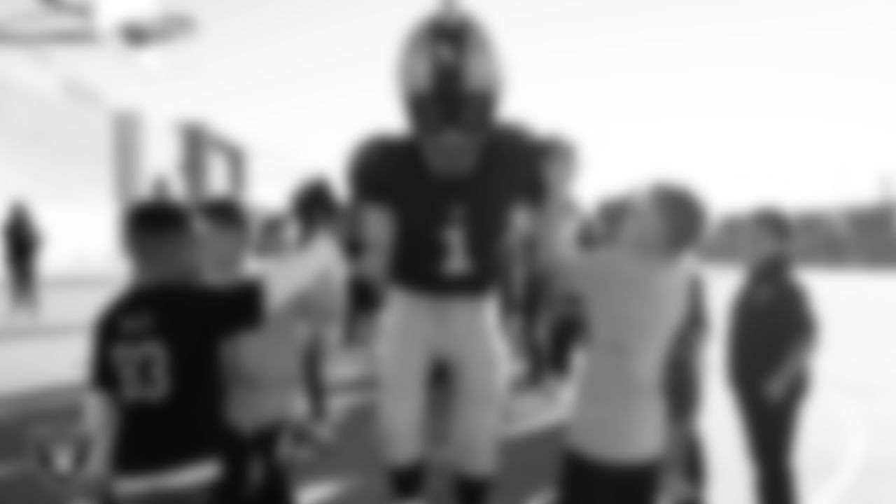 Raider Rusher high fives students during a Junior Raiders 
Training Camp at Somerset Academy Aliante.