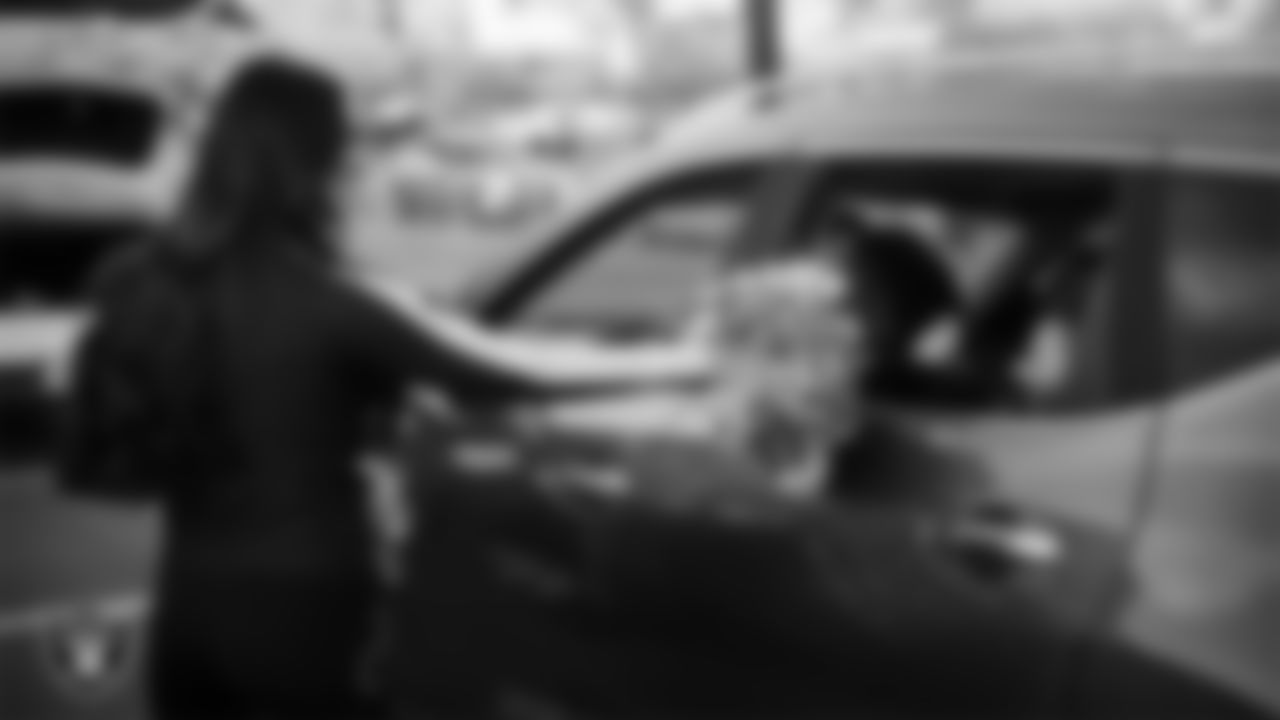 Raiderette Cheyanne waves to attendees during Turkey Time with the O-Line at Allegiant Stadium.