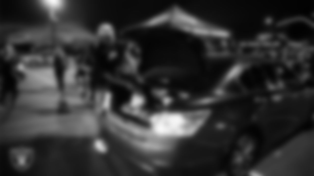 Las Vegas Raiders quarterback Aidan O'Connell (12) helps distribute Thanksgiving meals to families during Turkey Time with the O-Line at Allegiant Stadium.