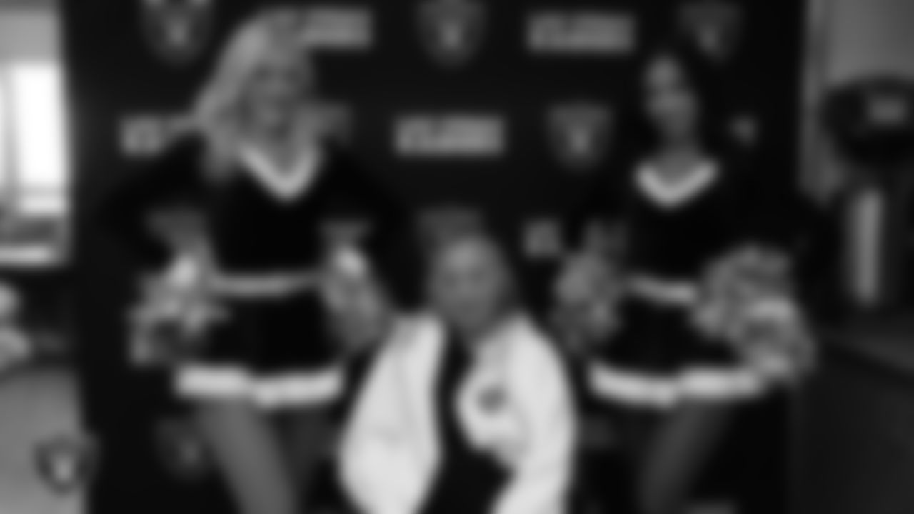 Raiderettes Kennedy and Cierra pose for a photo with a veteran during the annual Cox Salute to Service Tailgate at Southern Nevada State Veterans Home.