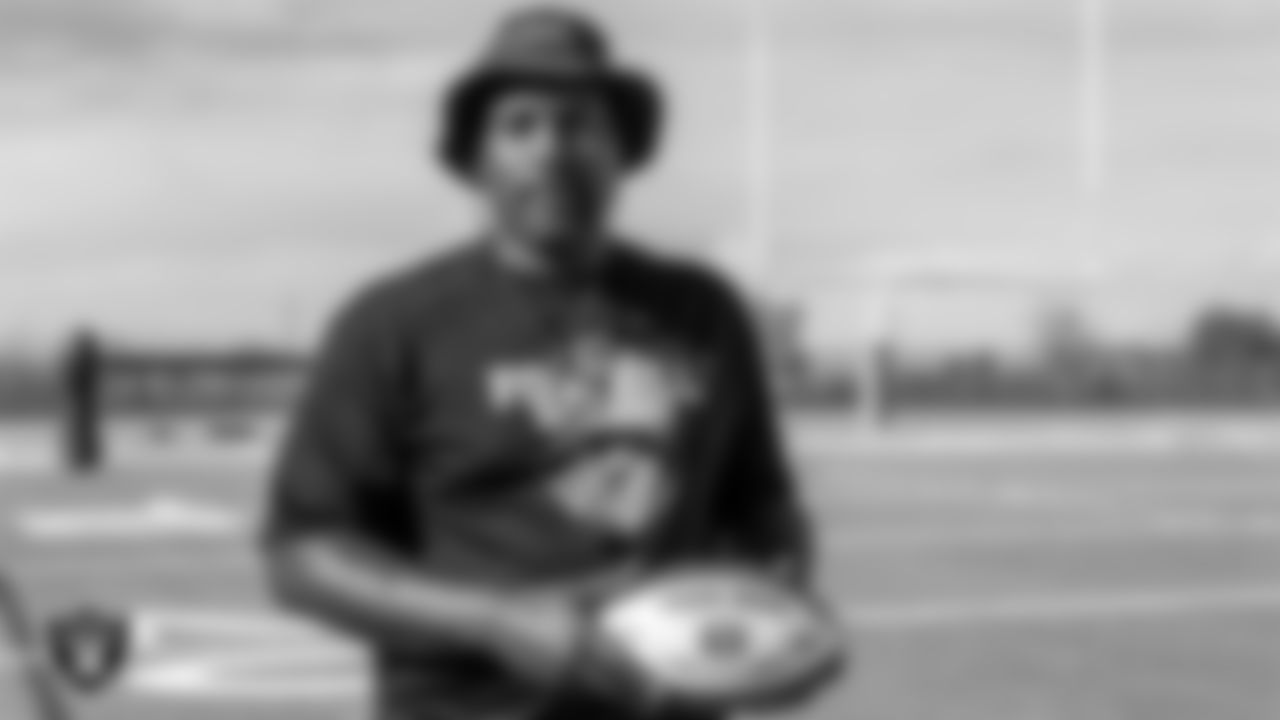 Foothill High School football coach Vernon Brown poses for a photo with the Tom Flores Coach of the Week custom football during practice at Foothill High School.