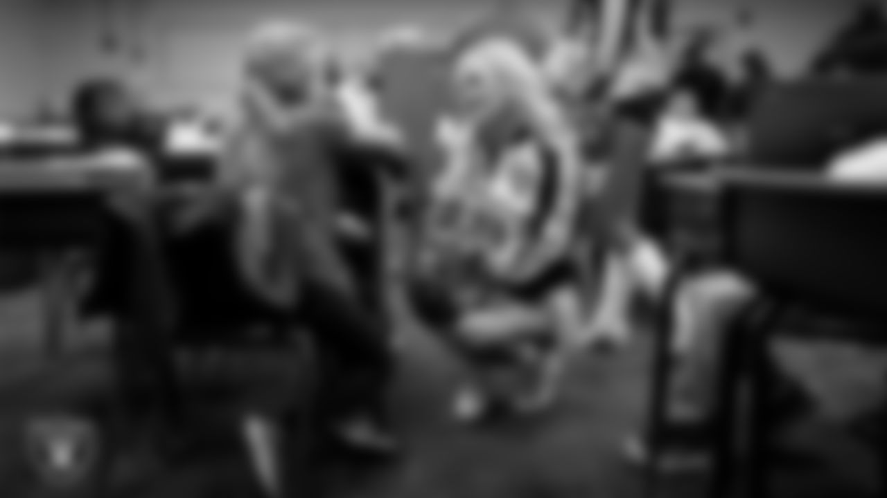 Raiderette Pip speaks to a student during a 'Lil Raiders Pop-Up at Matt Kelly Elementary School.