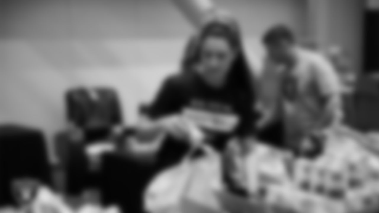 Las Vegas Raiders staff members help pack meals during the Raiders Holiday Meal Packing Party at Intermountain Health Performance Center.