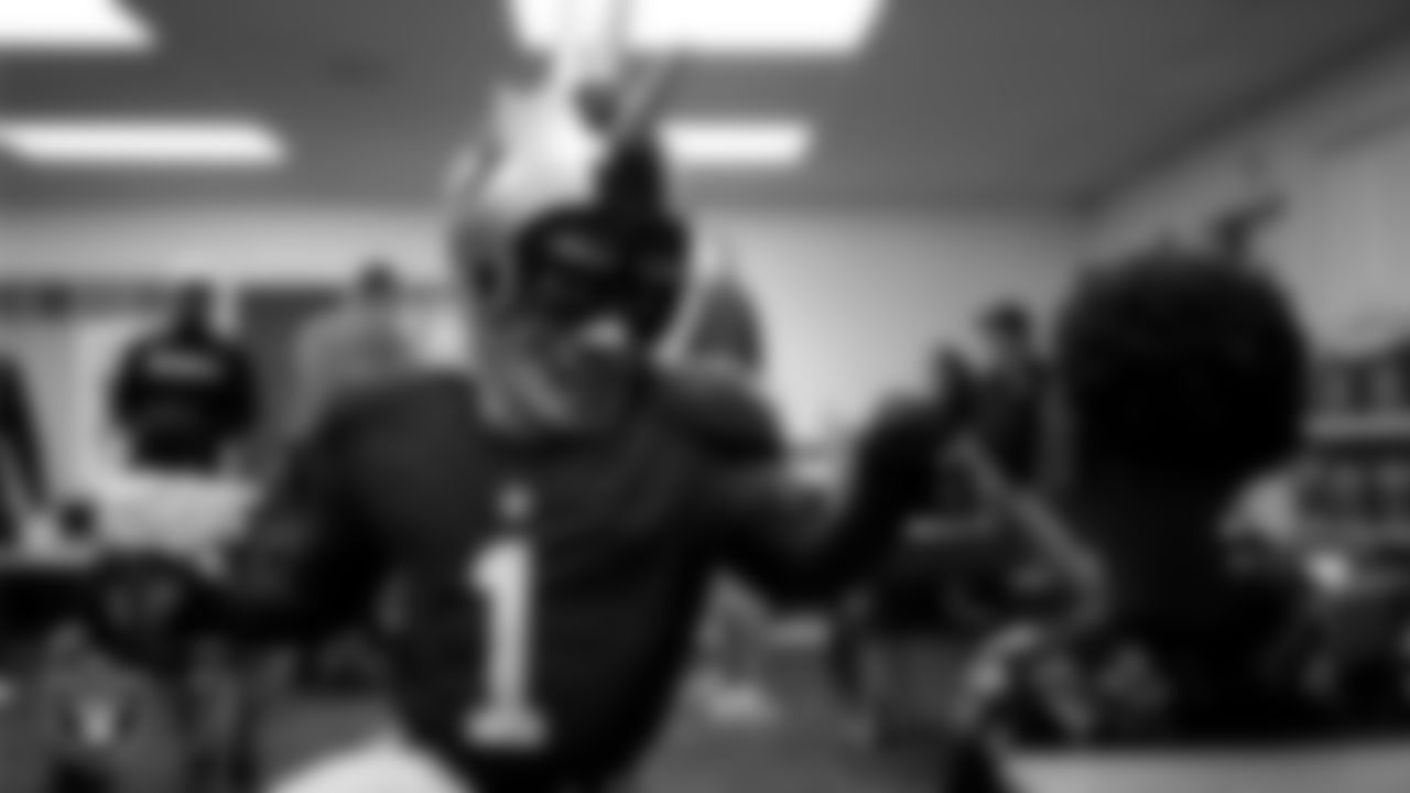 Raider Rusher gives a fist bump to a student during a 'Lil Raiders Pop-Up at Matt Kelly Elementary School.