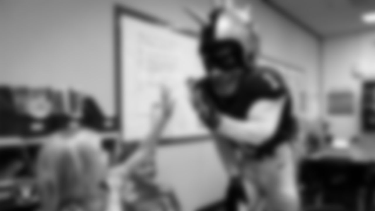 Raider Rusher gives a high-five to a student during a 'Lil Raiders Pop-Up at Richard H. Bryan Elementary School.