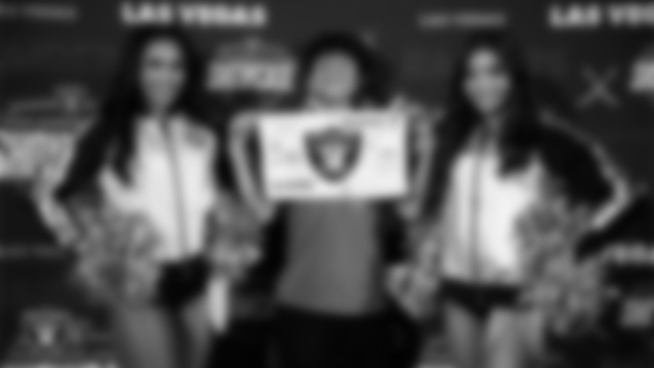 Raiderettes Cierra and Maddie pose for a photo with a fan before the Las Vegas Raiders' Football Showcase game at Moapa Valley High School.