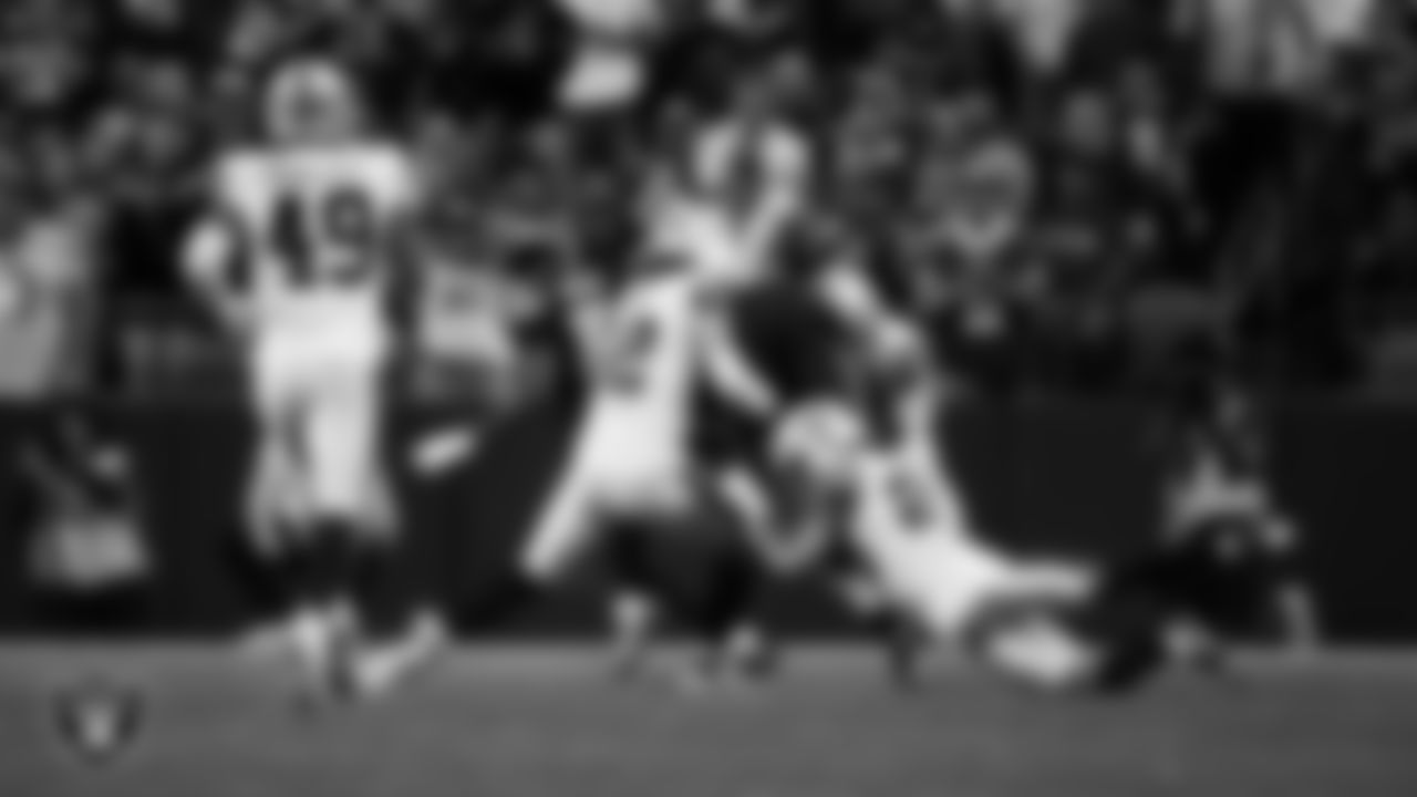 Las Vegas Raiders linebacker Matt Jones (42), safety Isaiah Pola-Mao (20) and cornerback Decamerion Richardson (25) make a tackle during the preseason away game against the Seattle Seahawks at Lumen Field.