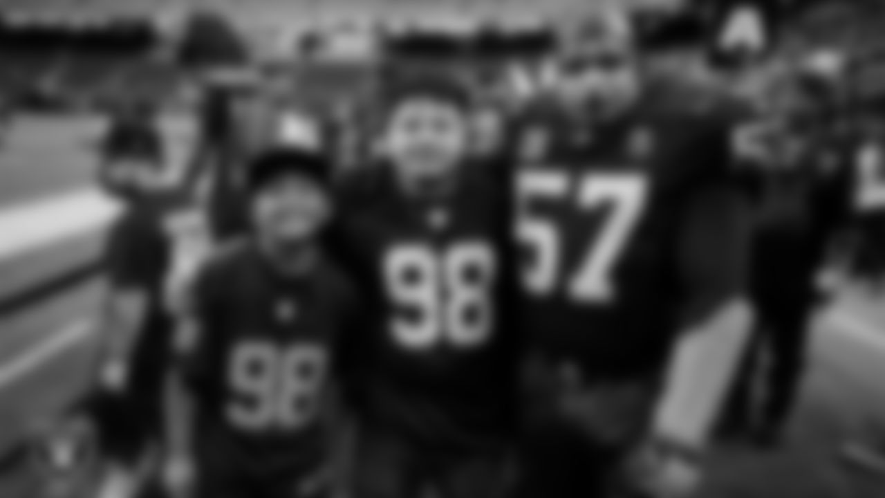 Christopher Arias and Marcos Carrillo from Make-A-Wish pose for a photo with The Violator on the sidelines before the Las Vegas Raiders' regular season home game against the Jacksonville Jaguars at Allegiant Stadium.