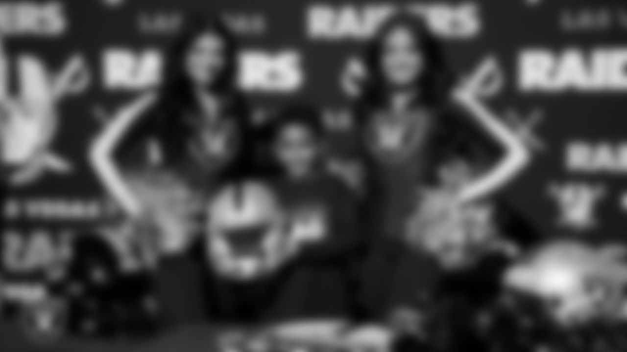 Raiderettes Kylee and Sloane pose for a photo with an athlete during the LEEAP Flag Football Tournament at Desert Breeze Park.