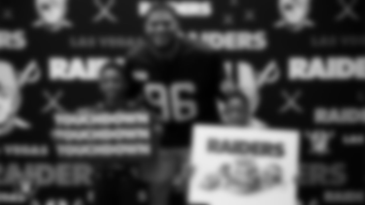 Las Vegas Raiders defensive tackle Jonah Laulu (96) poses for a photo with guests during a launch event at Aliante Library.